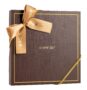 Brązowe pudełko prezentowe z ozdobną złotą wstążką.