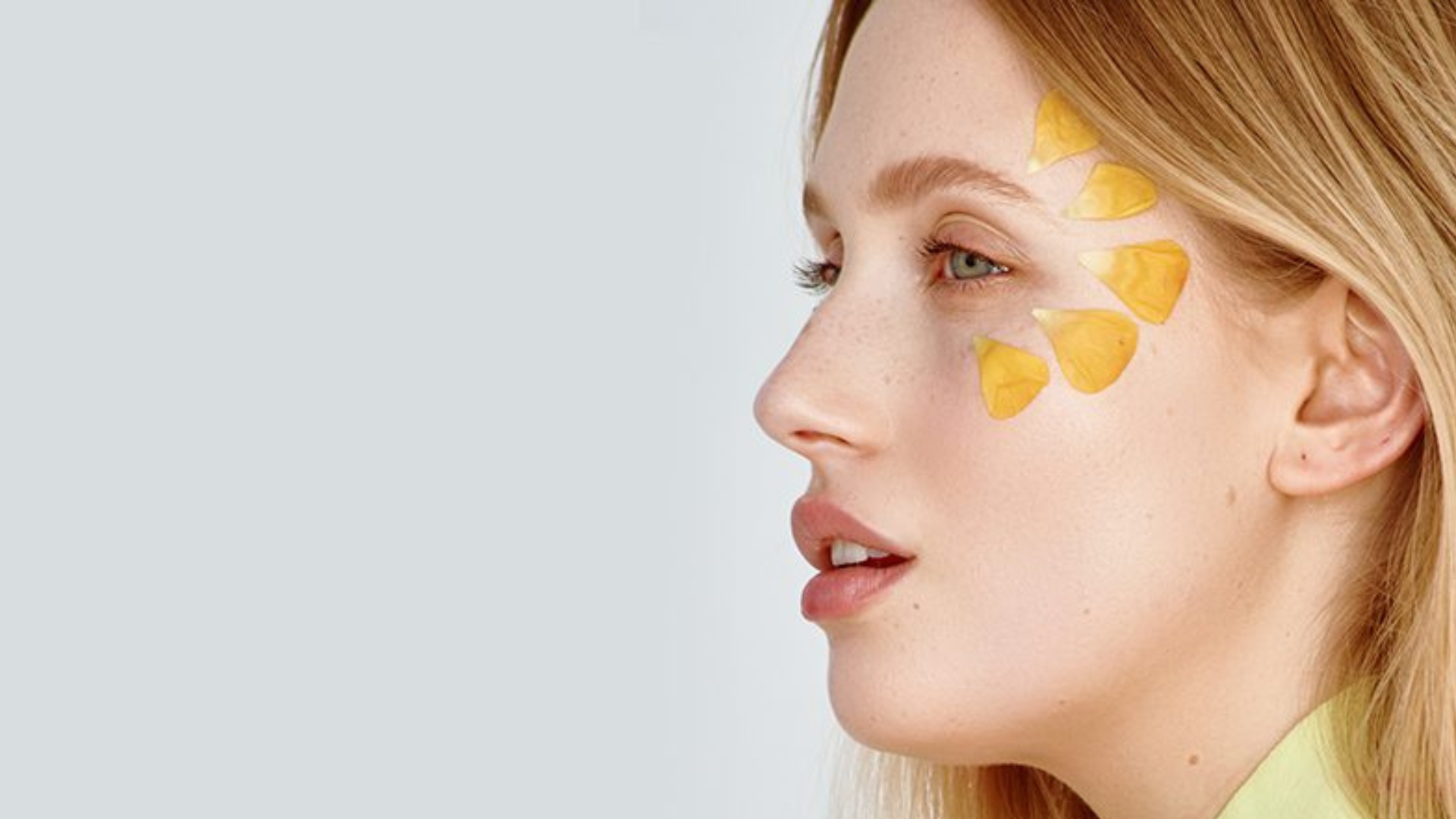 Profil kobiety z płatkami kwiatów na twarzy.