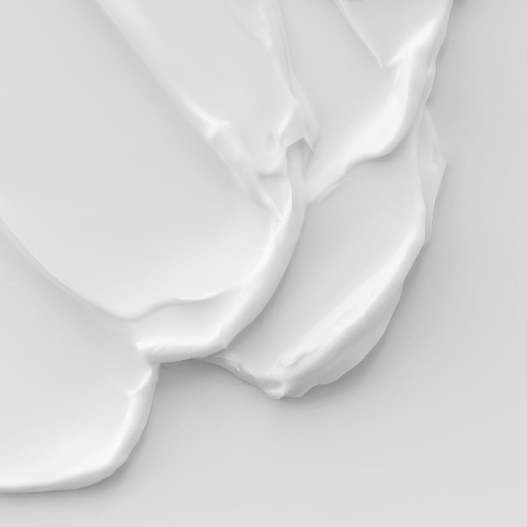 Tekstura białego kremu na skórę.