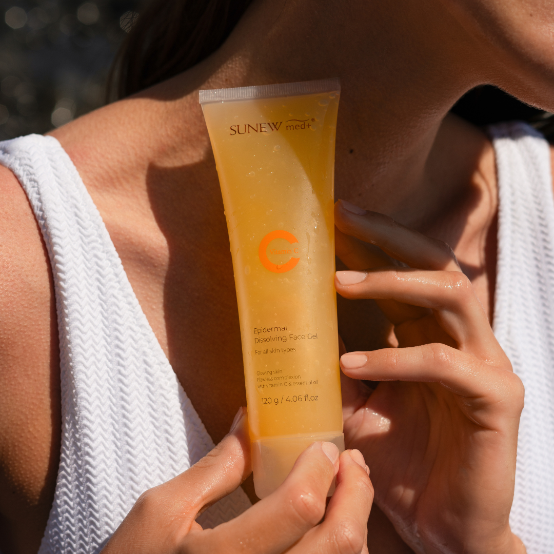 Osoba trzymająca tubkę żelu do twarzy z witaminą C.