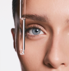 modelka z pipetą z serum przy policzku